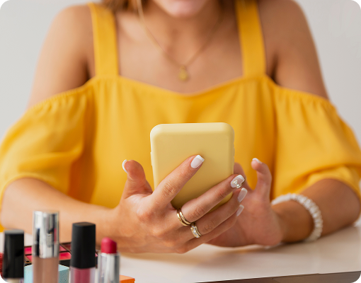Nail technician using mobile booking app to manage client appointments.