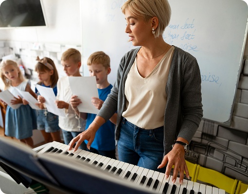music studio teacher leading group piano class with children